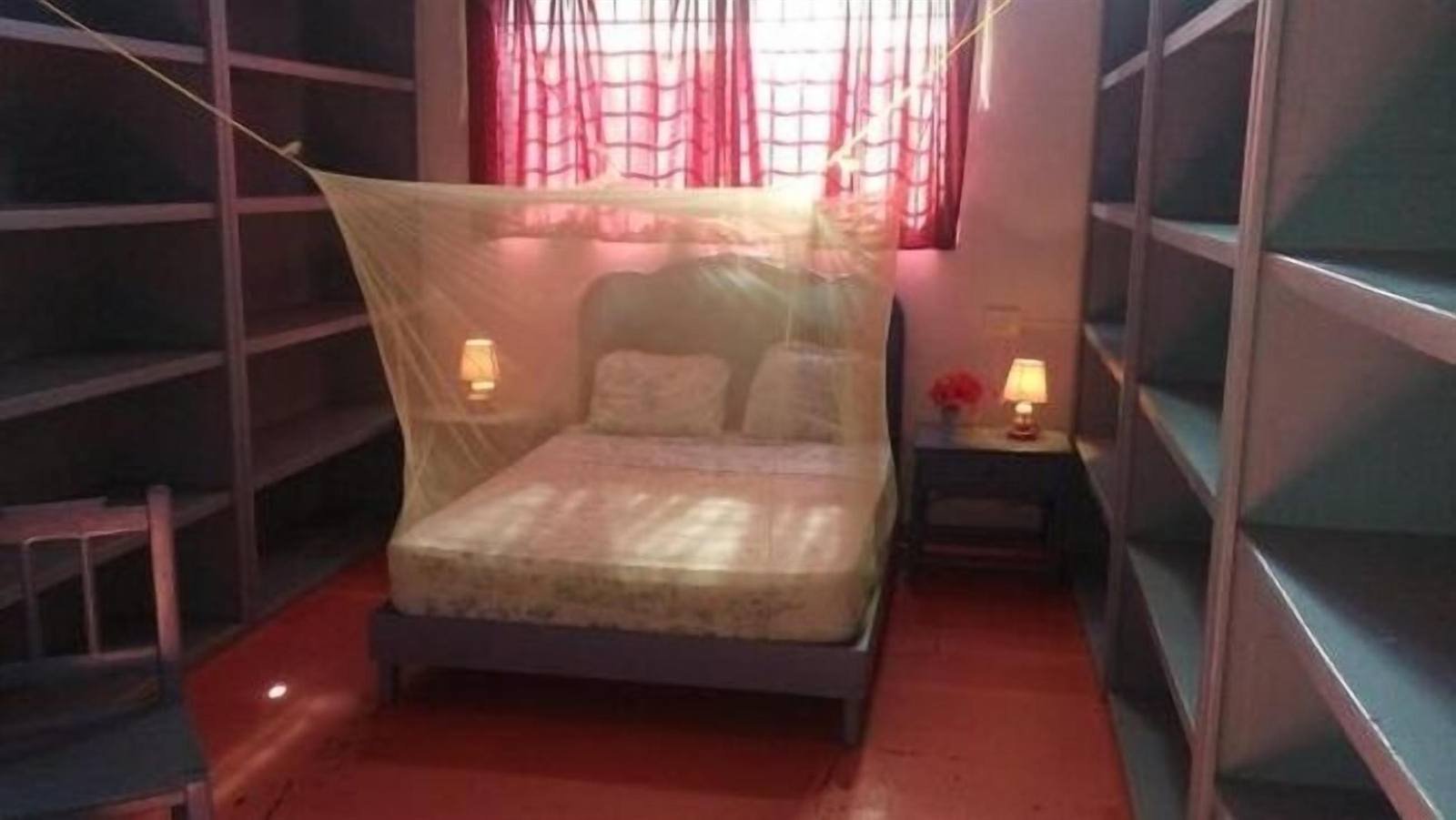 Double bed with mosquito net and open shelves